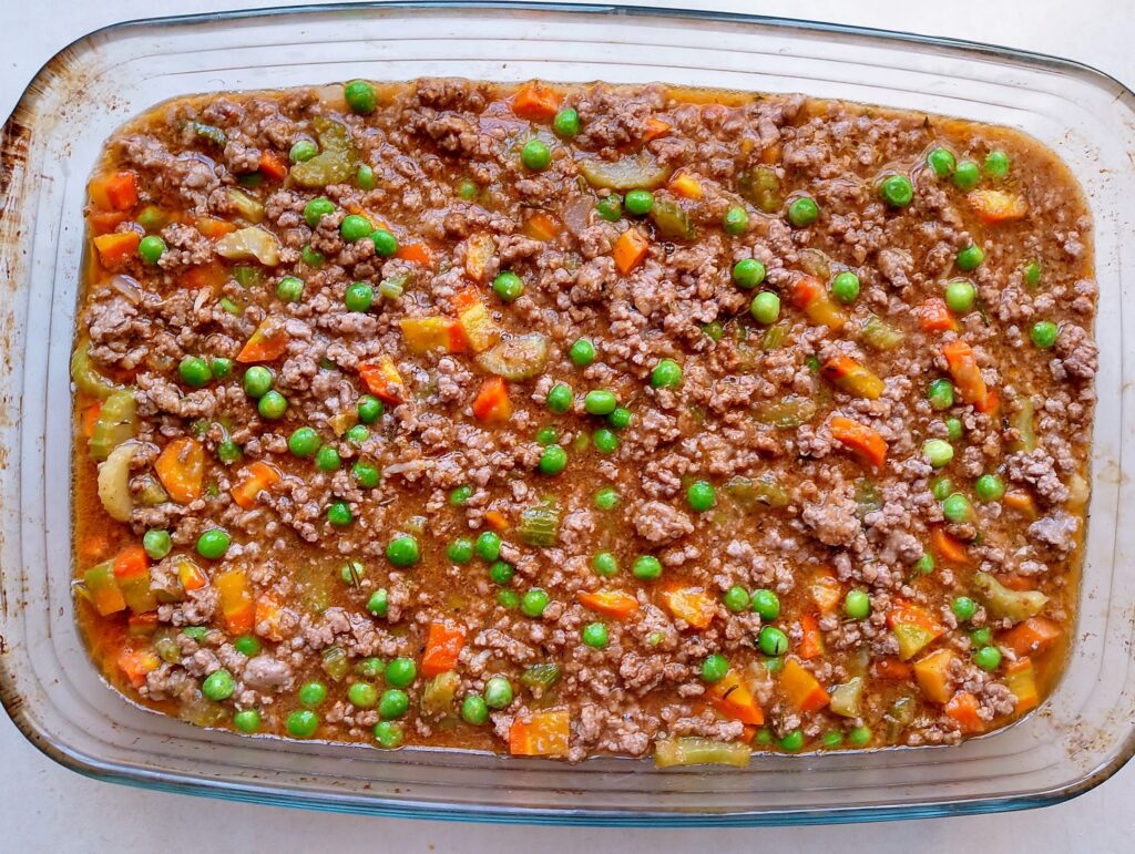 Pouring the cottage pie filling into the casserole dish