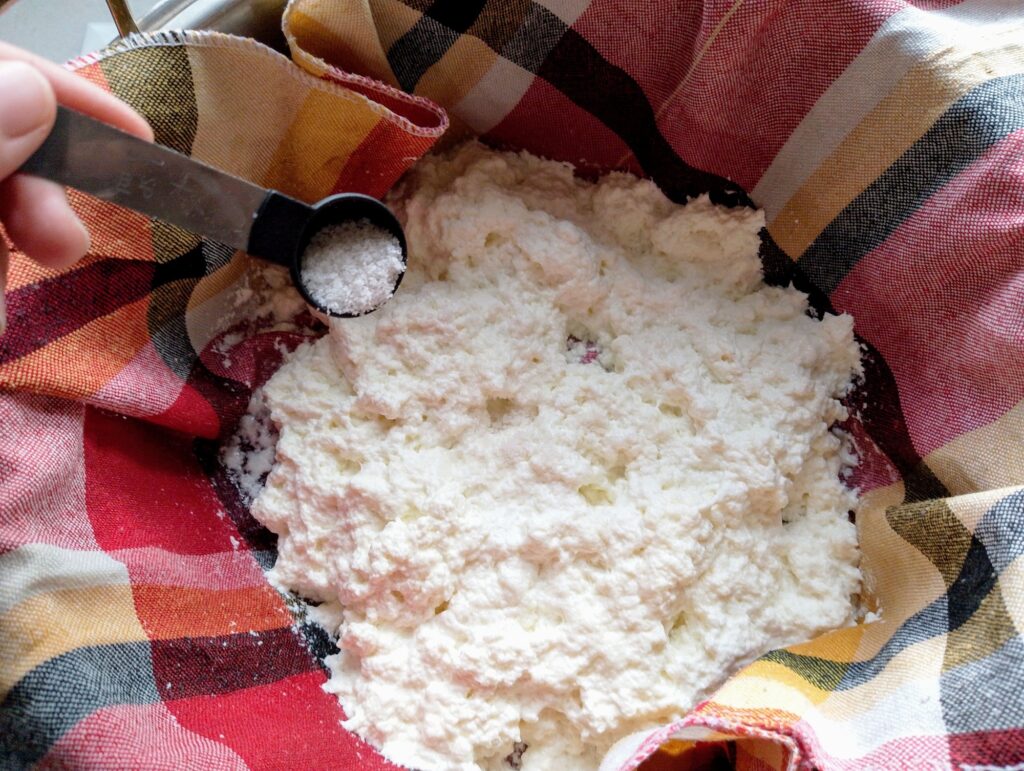 Sprinkling salt onto the fresh cheese curds