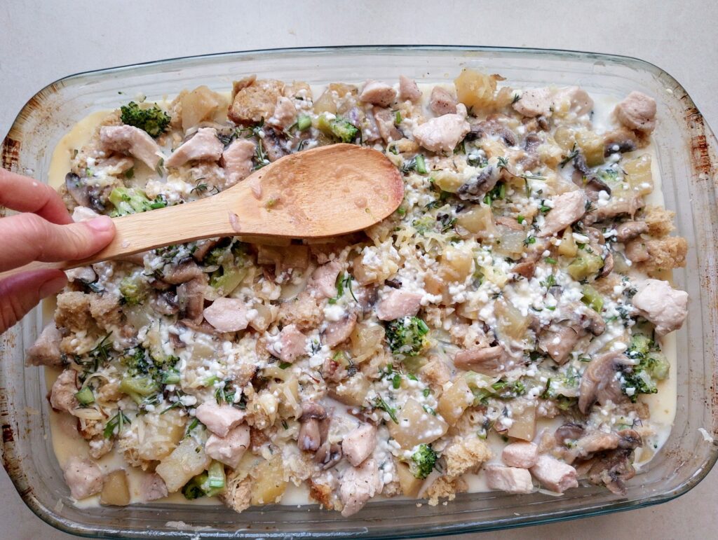 Pressing down on the cubed sourdough bread to make it absorb the custard sauce