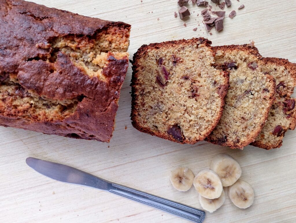 Freshly baked sourdough discard banana bread sliced on a wooden board