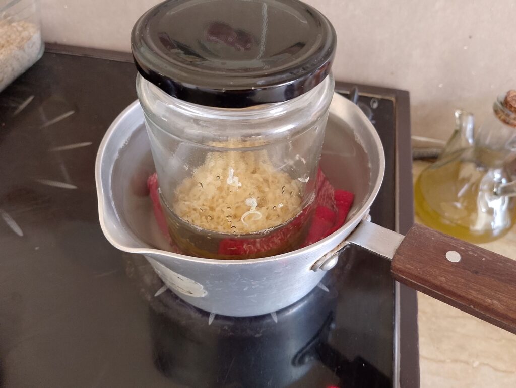 Melting grated beeswax in calendula infused olive oil in a double boiler