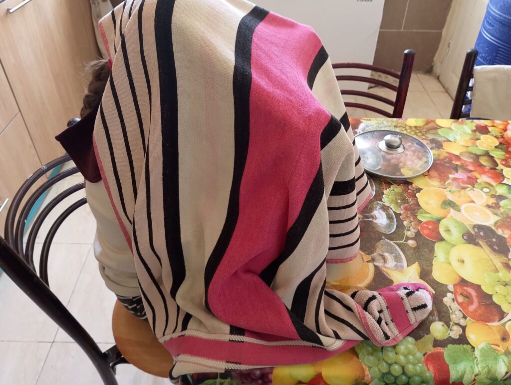 Covering face and head with a towel and steaming over the pot with hot herbal water