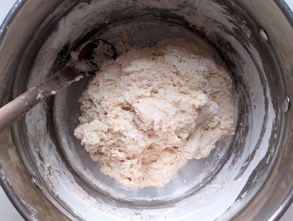 Adding flour to the wet ingredients for sourdough pita bread