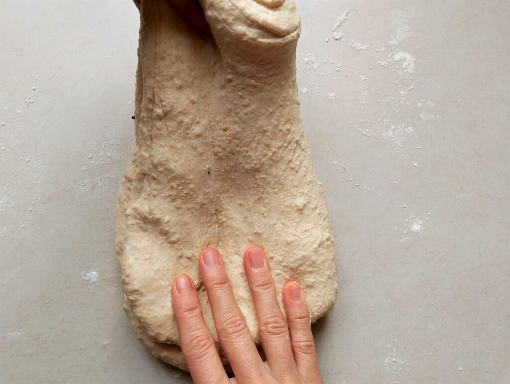 Performing stretch and folds on the pita bread dough