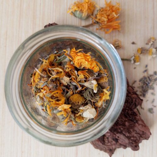 Herbs for a DIY herbal steam facial in a glass jar