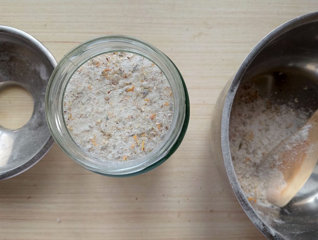 Transferring the ready herbal bath salts to a jar for storage