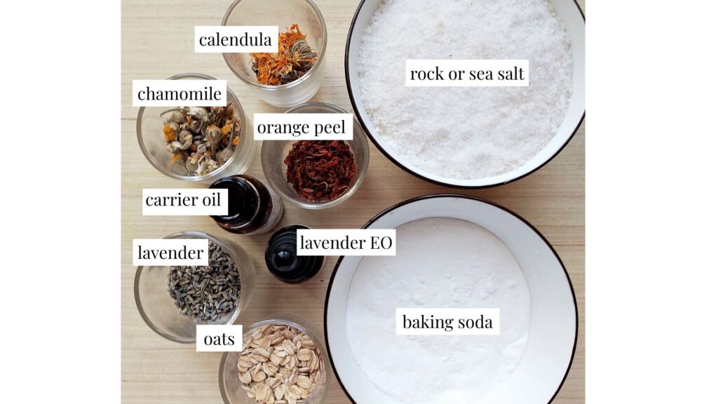 Ingredients for homemade herbal bath salts on a wooden table