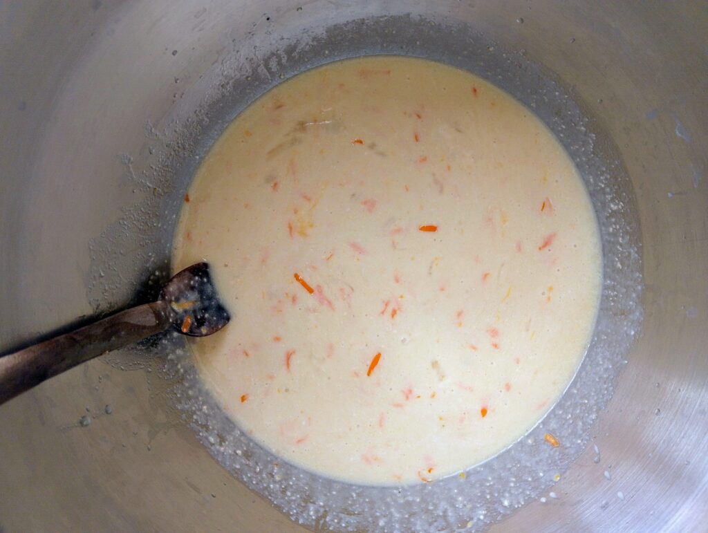 Mixing the wet ingredients for sourdough discard orange cinnamon rolls in a bowl