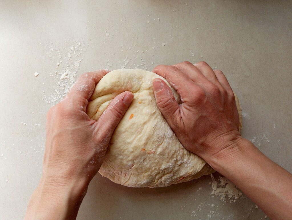 Woman kneading the dough for orange cinnamon rolls