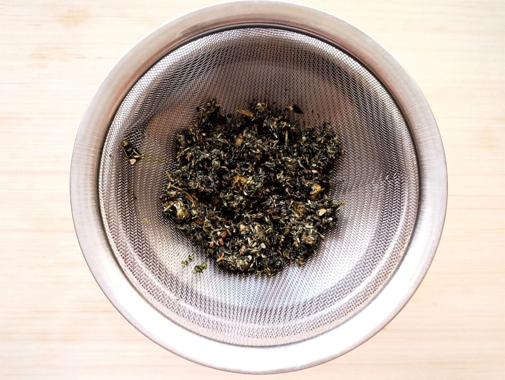 Straining herbs over a fine mesh sieve