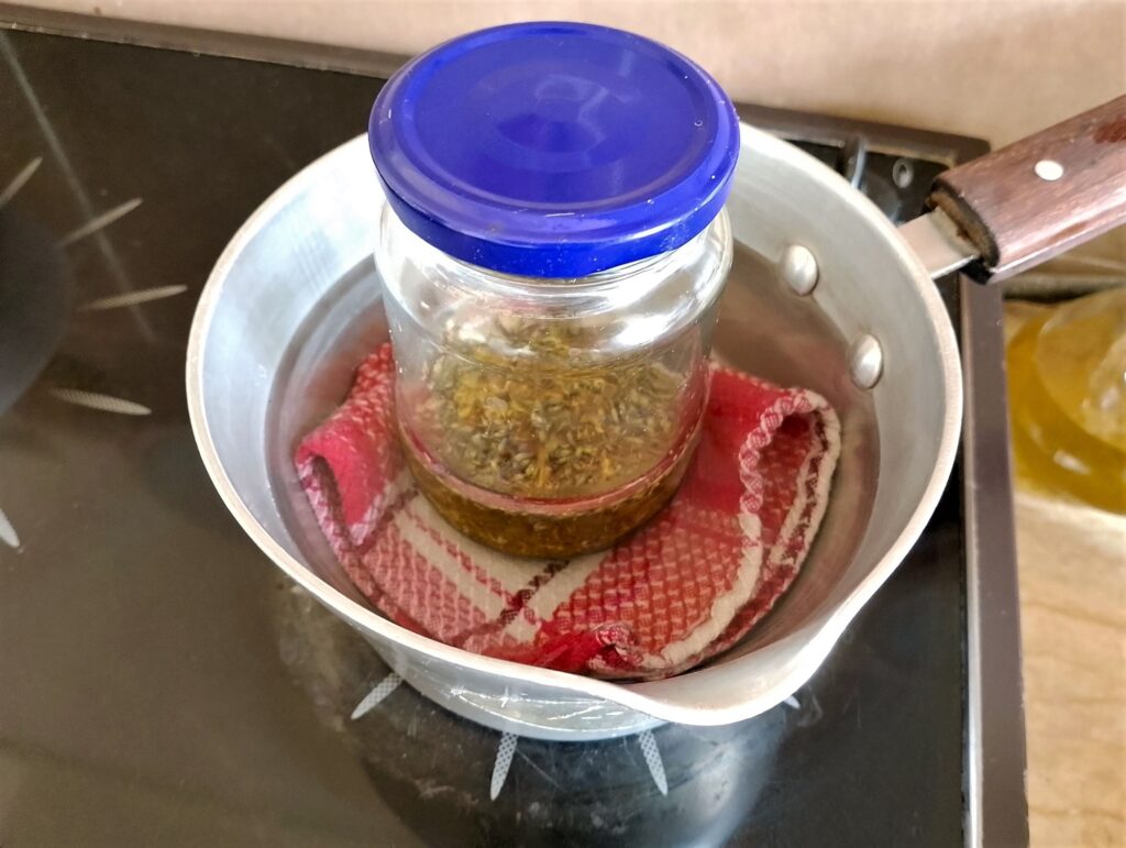 Heating the herbal oil in a gentle water bath