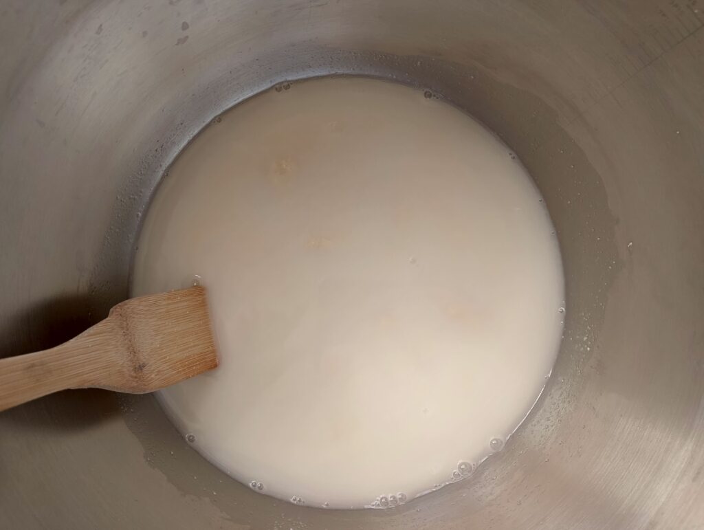 Mixing water and active starter in a bowl