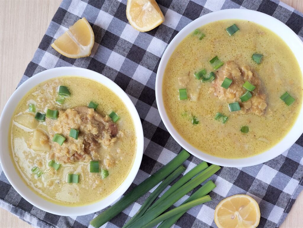 Red lentil and chicken stew in bowls, garnished with sliced green onions