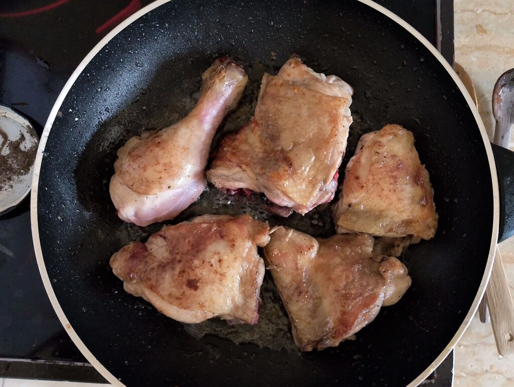 Browning chicken pieces in a skillet