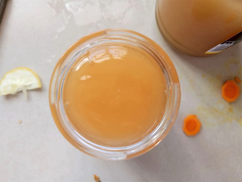 Pouring raw honey over fresh ingredients in jar