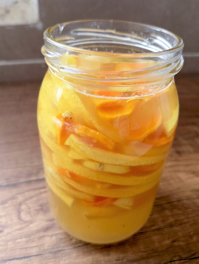 Jar of fermented lemon, turmeric and ginger honey on a wooden table