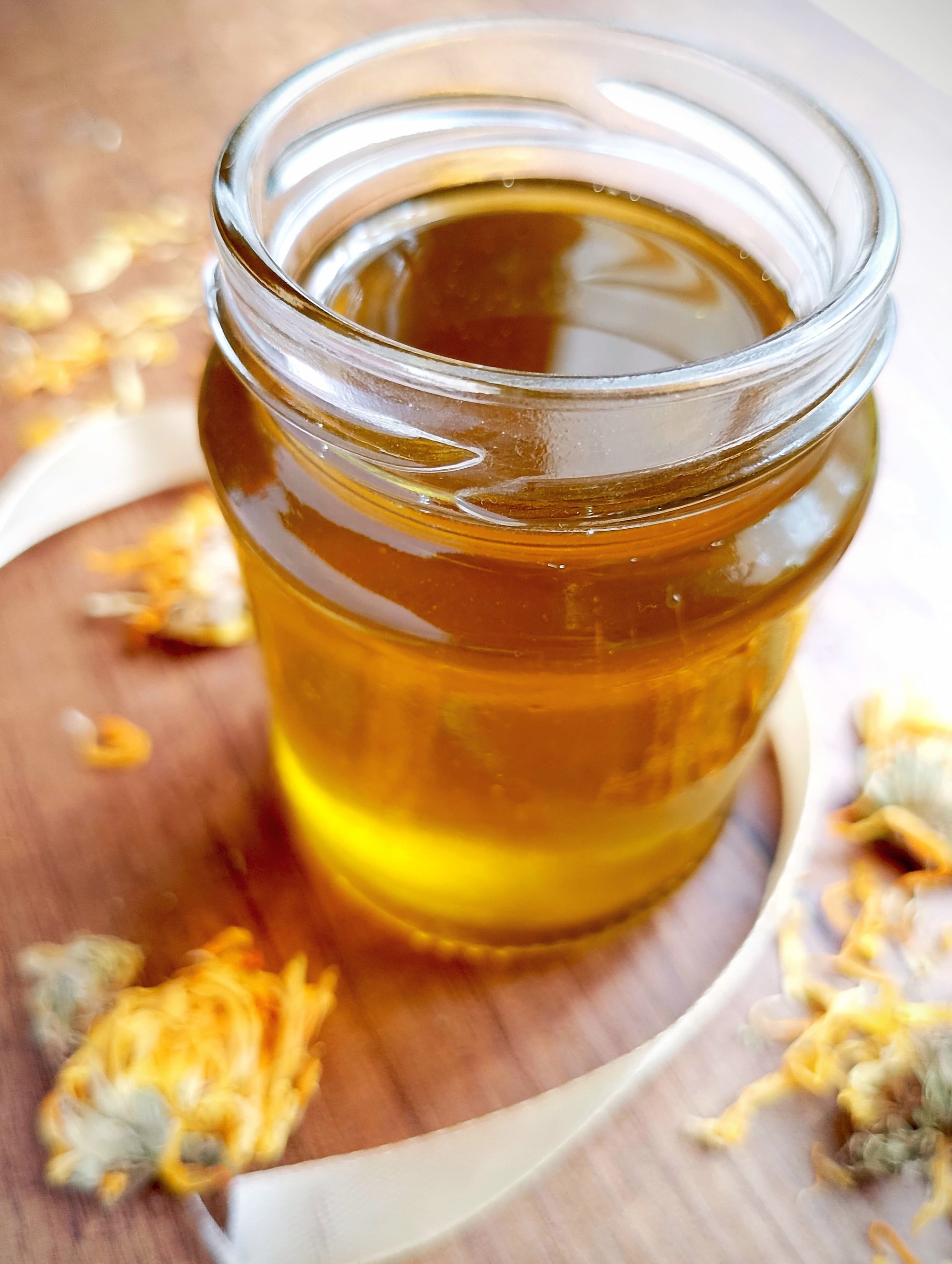 How to make calendula oil: jar of calendula oil on wooden table