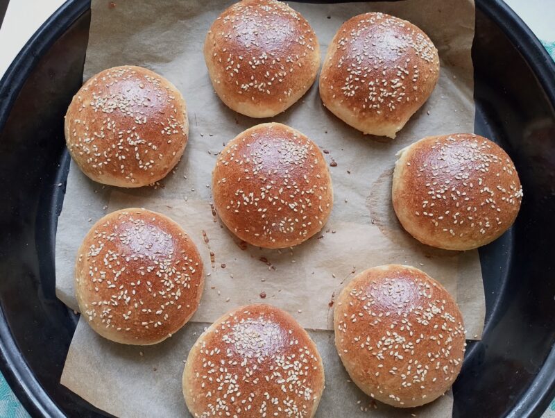 Burger buns on lined baking tray