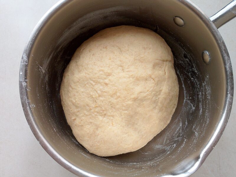 Sourdough discard burger buns dough placed in a greased bowl for bulk fermentation