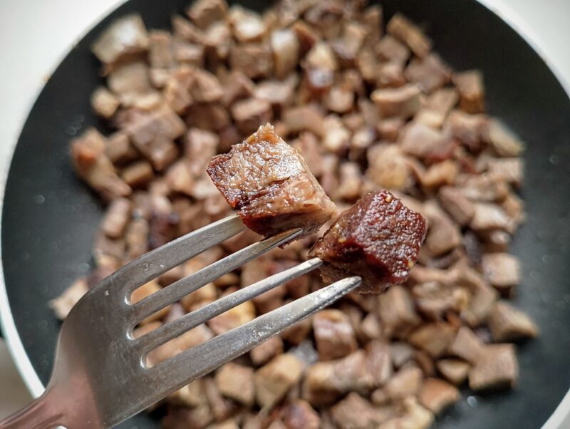 Crispy cubes of beef tongue on fork