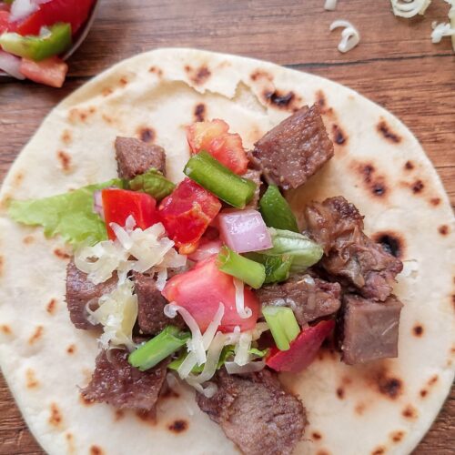 Beef tongue taco on wooden table