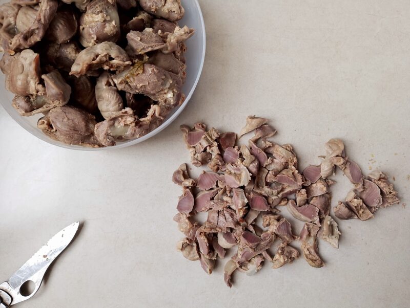 Slicing cooked chicken gizzards for soup