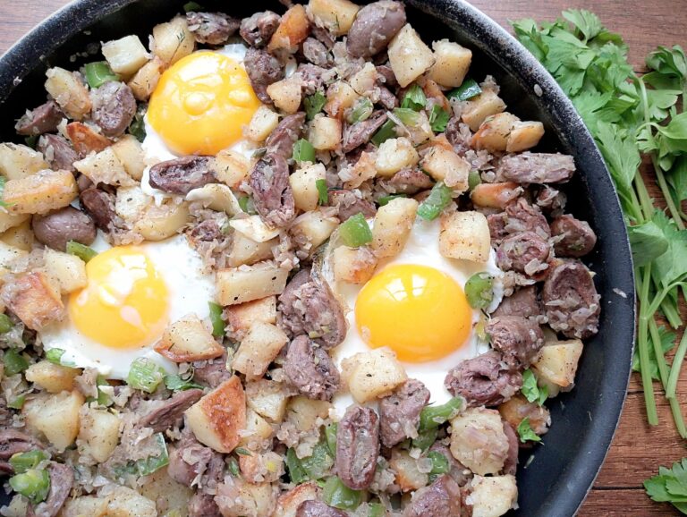 Chicken hearts hash in skillet with fresh parsley on the side