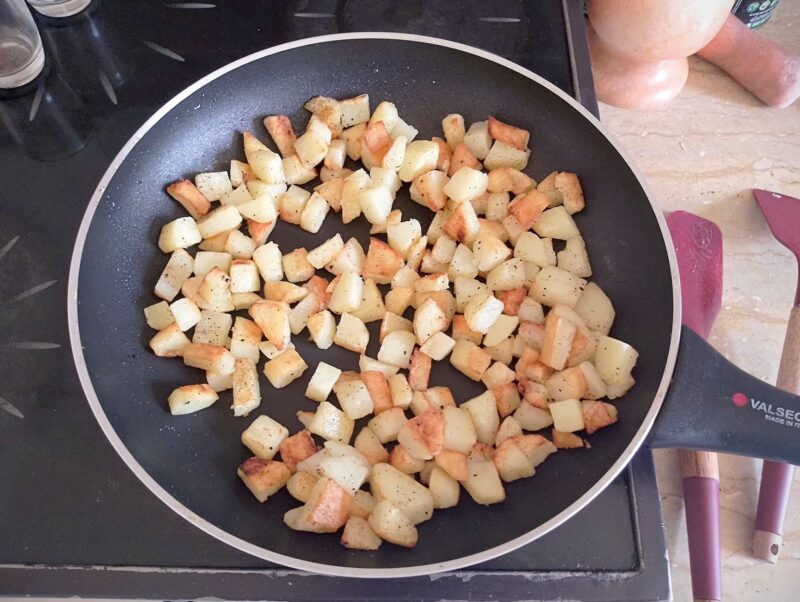 Frying cubed potatoes in skillet