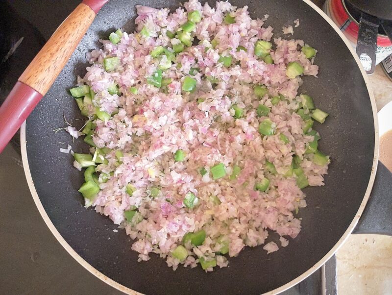 Sauteing chopped onion and bell pepper in skillet