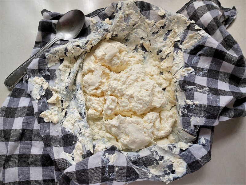 Well-drained fromage blanc in cheesecloth, ready to be transferred into a bowl