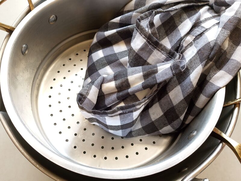 Fromage blanc draining in cheesecloth gathered into a bundle