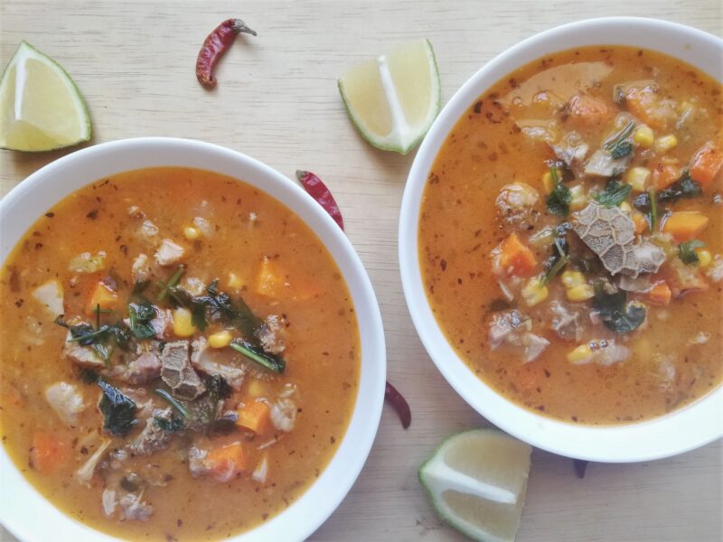 Traditional Mexican tripe soup in bowls on wooden table