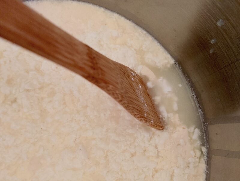 Curds separating from the whey in pot when heating clabbered milk for raw milk farmer's cheese