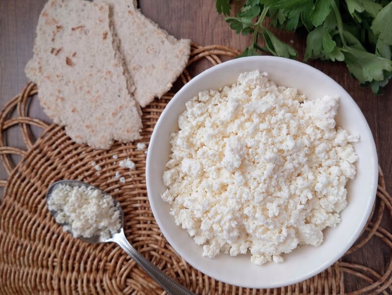 Raw milk farmer's cheese recipe: a bowl of raw milk farmer's cheese on table with flatbread on the side