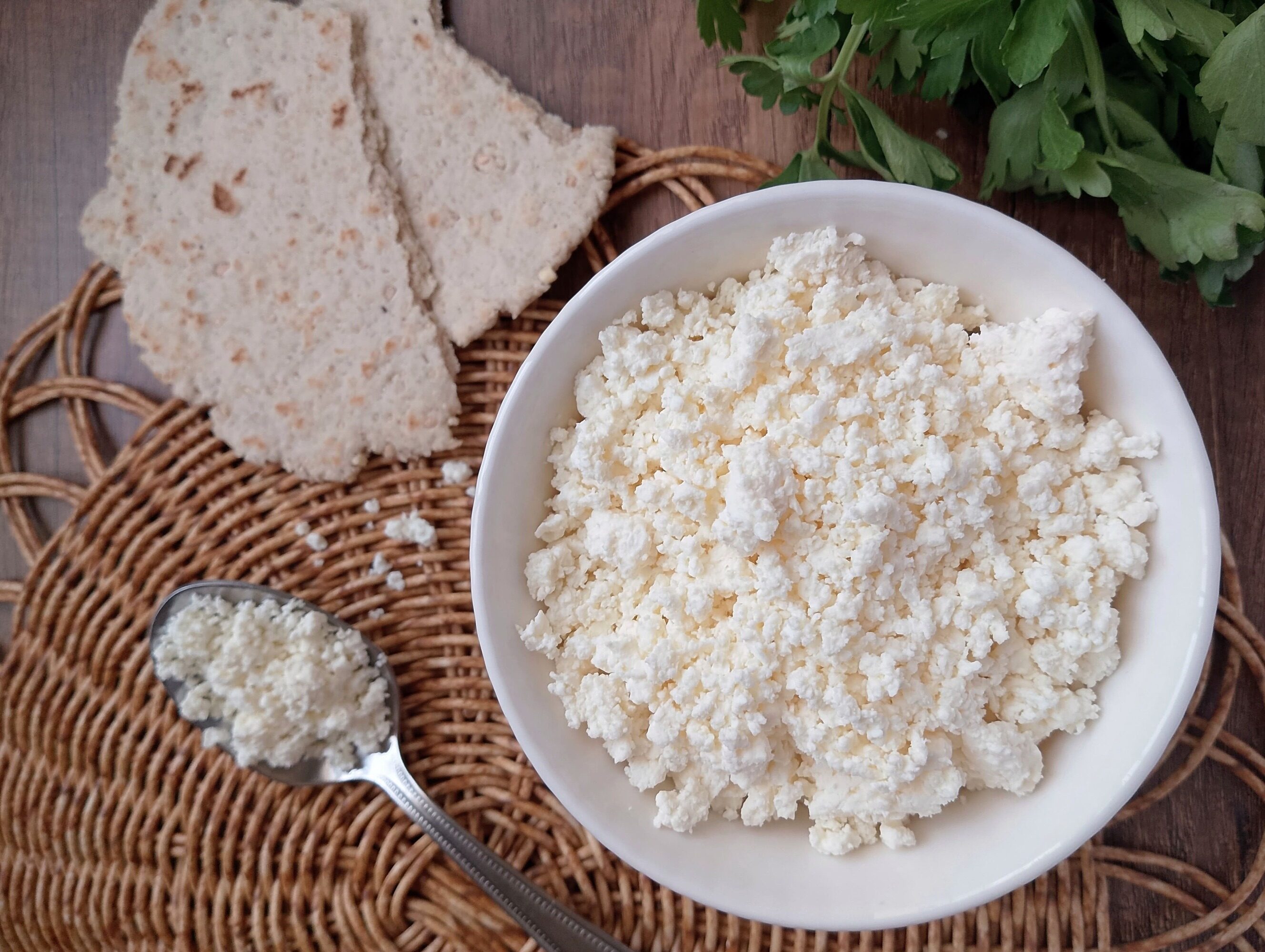 Raw milk farmer's cheese recipe: a bowl of raw milk farmer's cheese on table with flatbread on the side