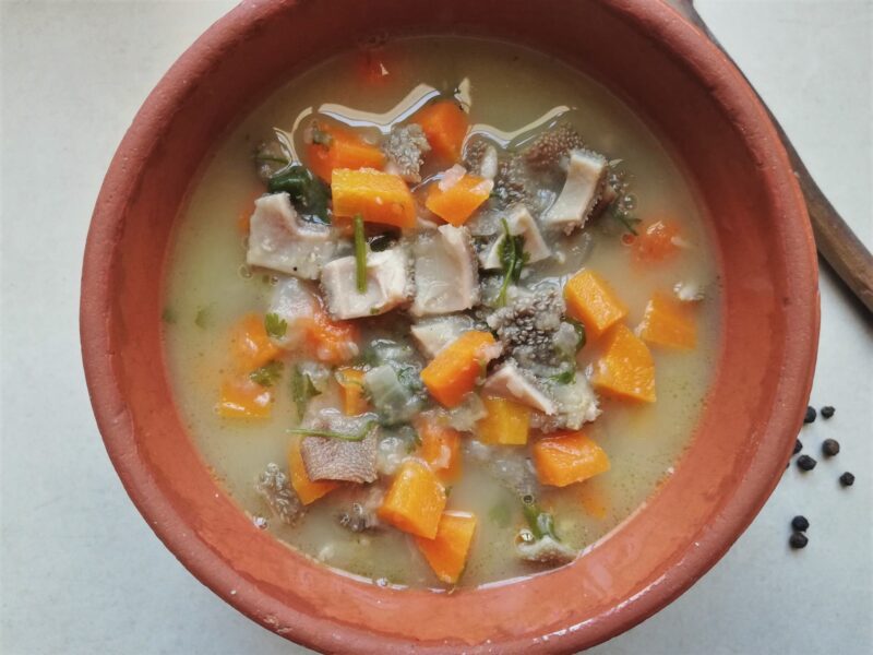 Tripe soup with carrots and onion served in rustic bowl