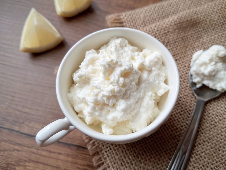 Kefir cheese in serving cup with a teaspoon of cheese on the side
