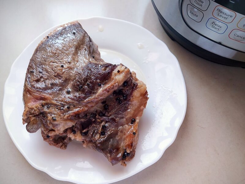 Pressure cooked beef tongue cooling on a plate
