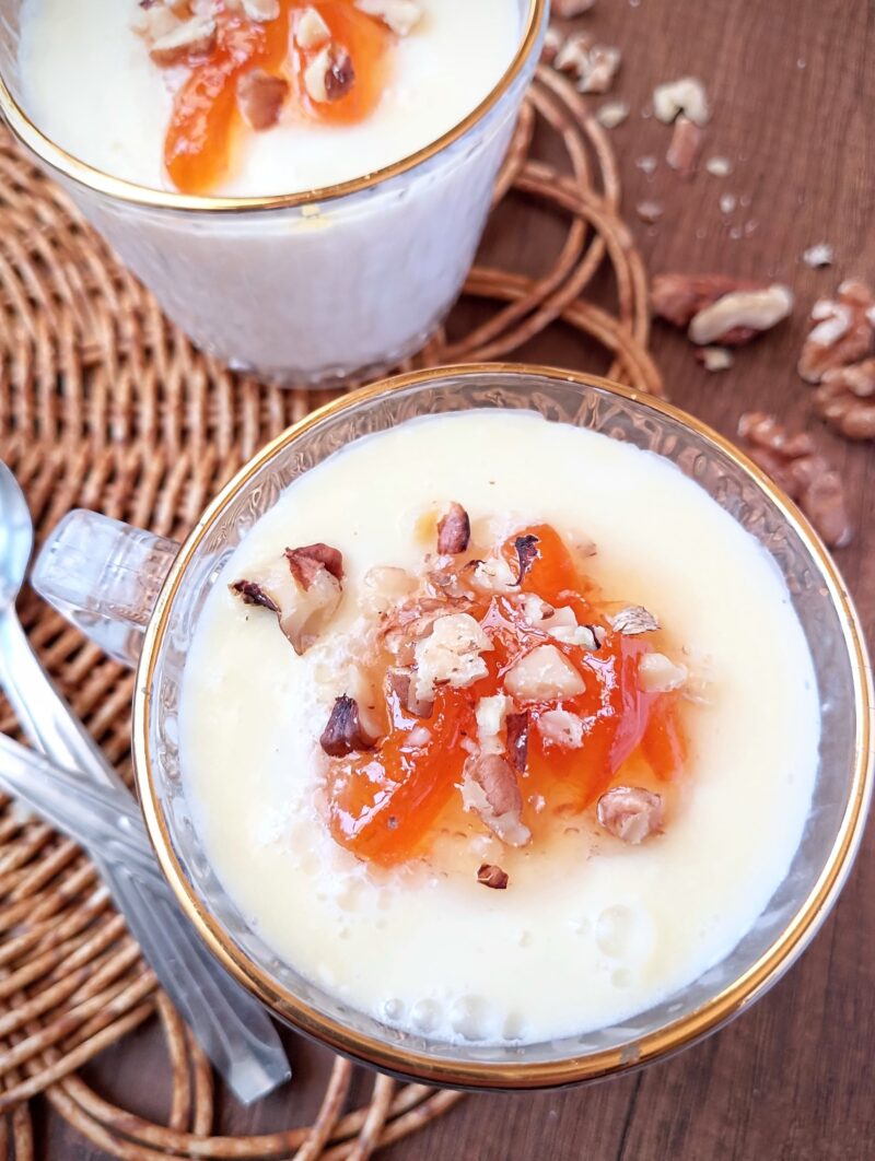 Homemade junket in cups, topped with orange marmalade and chopped walnuts