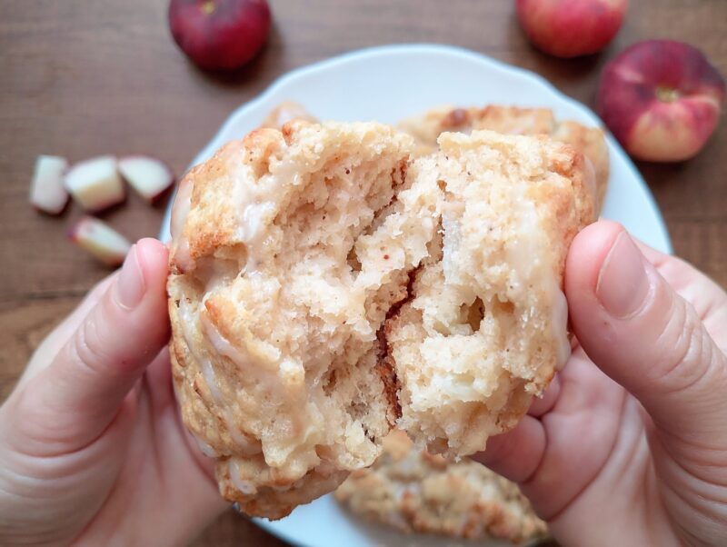 Woman's hands breaking sourdough scone in half to show inside texture