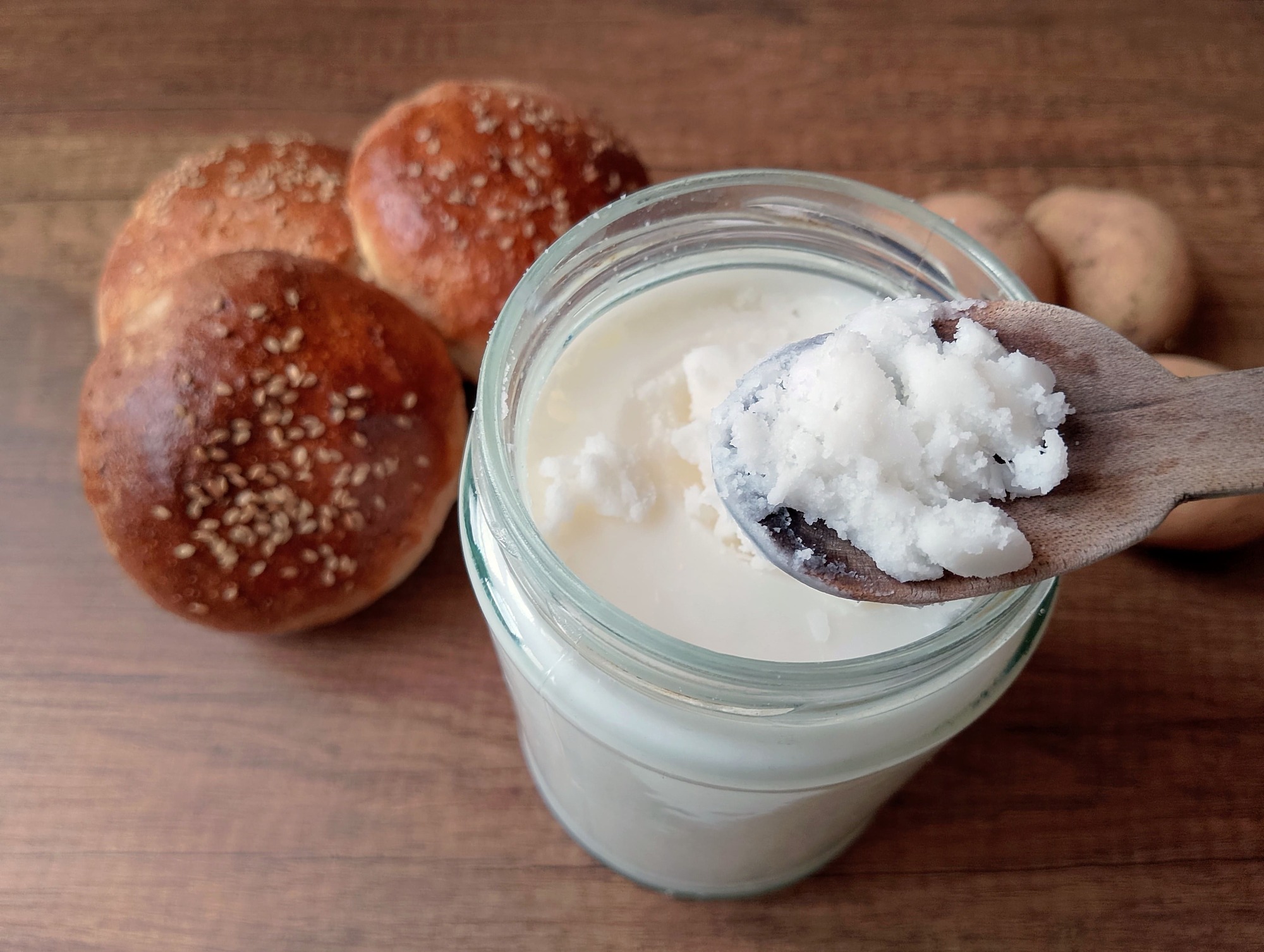 Wooden spoon scooping some beef tallow out of jar