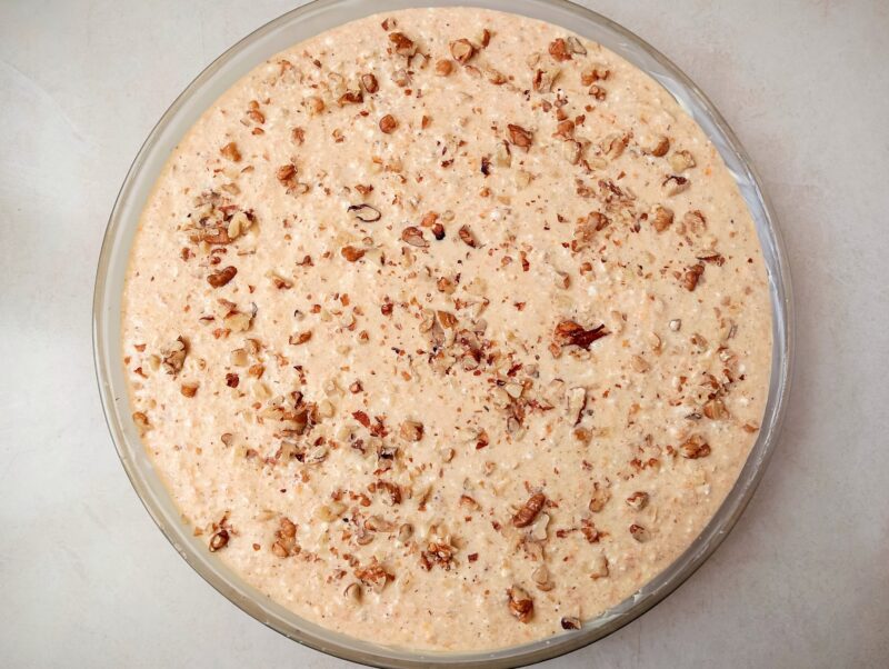 Spreading batter in baking dish and sprinkling chopped walnuts on top