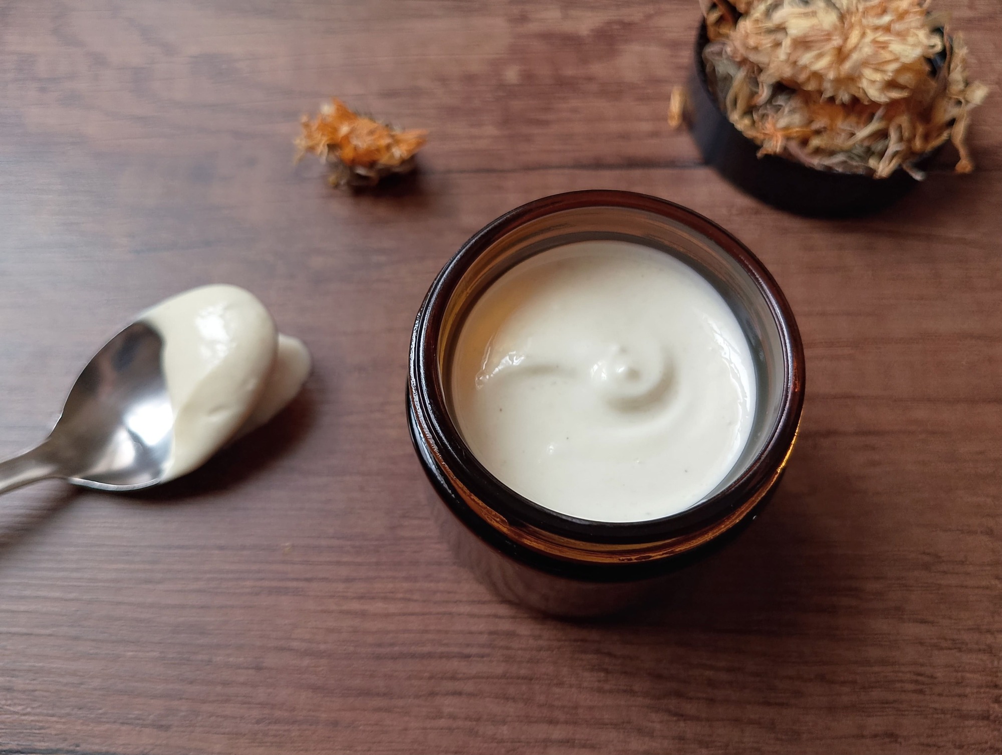 Calendula tallow cream in amber jar on wooden table