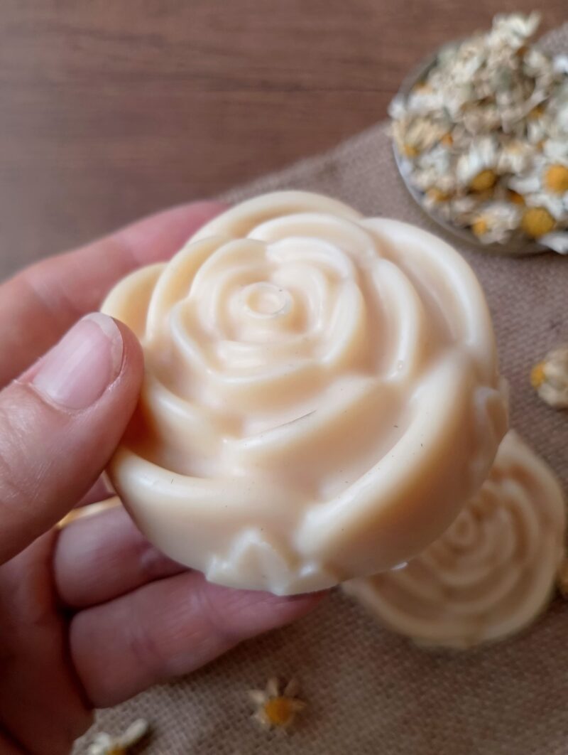 Womans hand holding tallow lotion bar