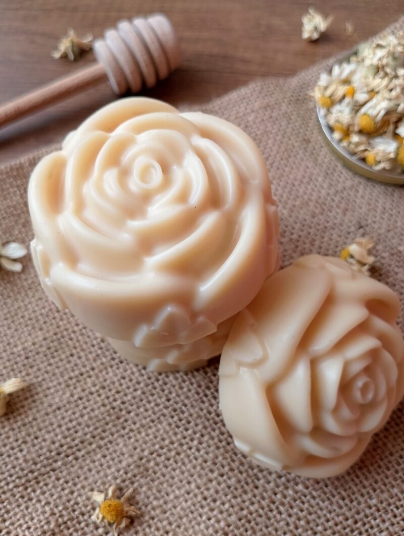 Tallow lotion bars stacked on burlap sack with chamomile flowers scattered around