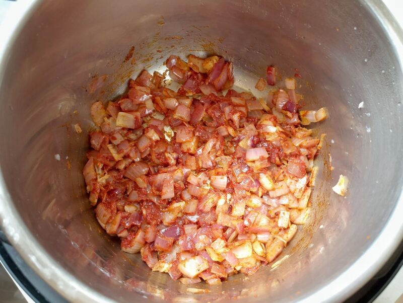 Blooming tomato paste and spices with onions in instant pot