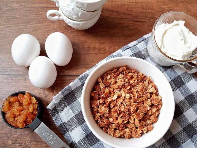 Homemaking habits: eggs, yogurt, granola, and raisins collected on wooden table