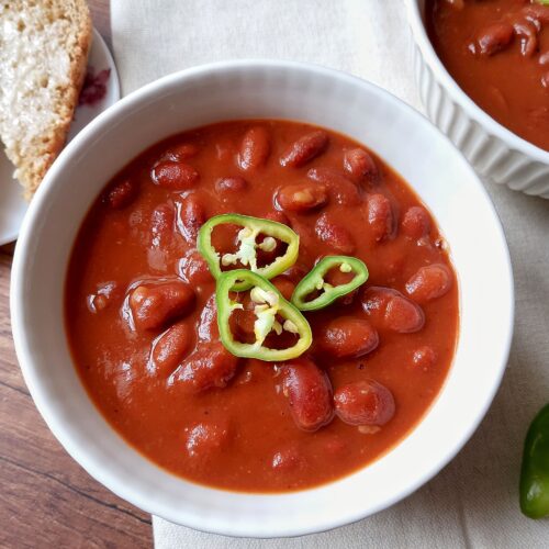 Baked beans in an instant pot: bowl of baked beans garnished with sliced mild chilies