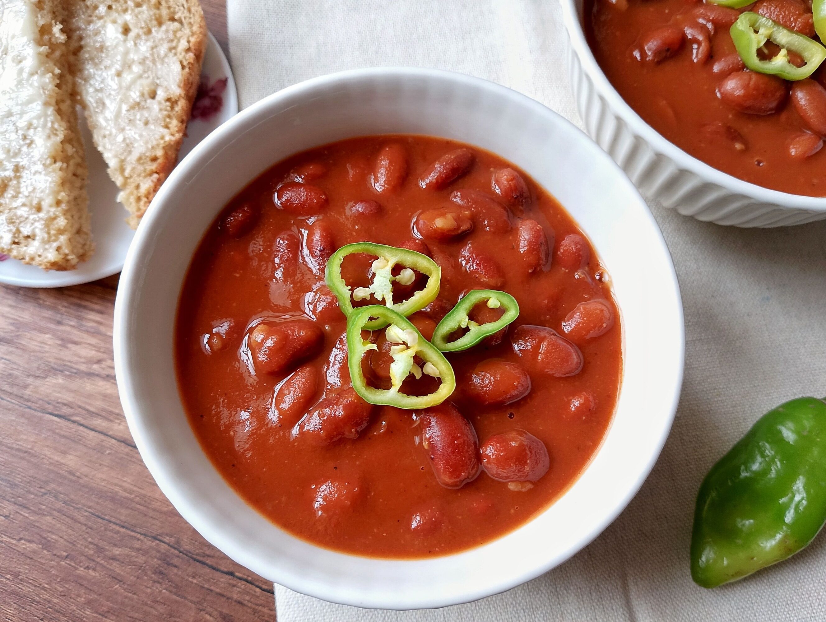 Baked beans in an instant pot: bowl of baked beans garnished with sliced mild chilies