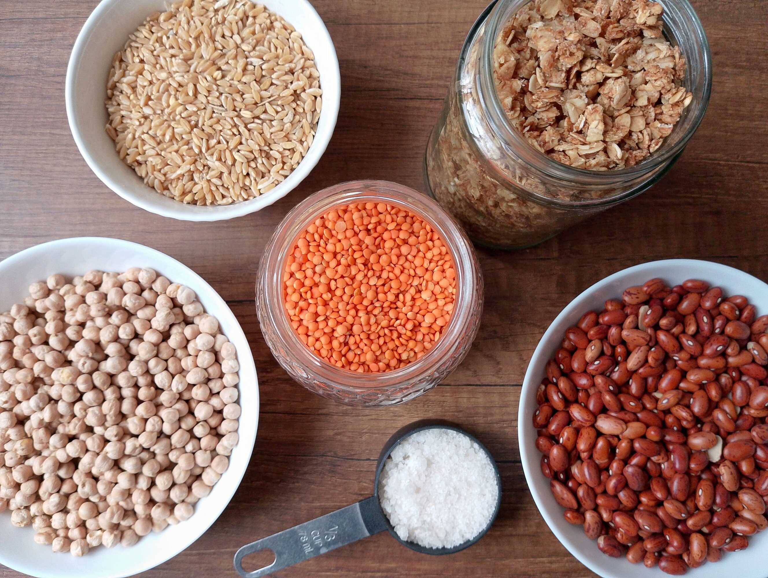 How to stock a real food kitchen on a budget: bowls and jars of pantry staples on table